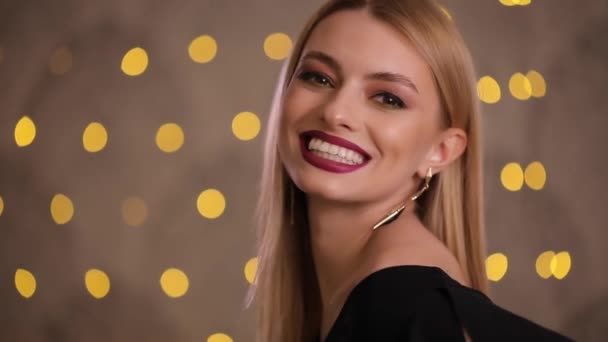 Koketa žena flirtuje pózuje na fotoaparát, slow motion, pozadí žluté bokeh — Stock video