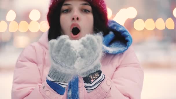 Gelukkige vrouw waait sneeuw in de winter, slowmotion — Stockvideo