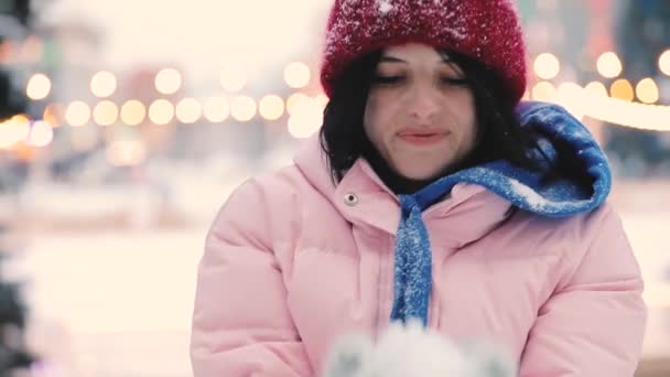 Gelukkige vrouw waait sneeuw in de winter, slowmotion — Stockvideo