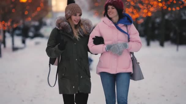 Счастливые женщины друзья прогуливаются по аллее вместе в зимний день — стоковое видео