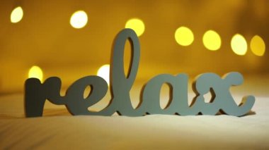 Word Relax bir yatakta sarı bulanık ışık bokeh arka plan ile silüeti