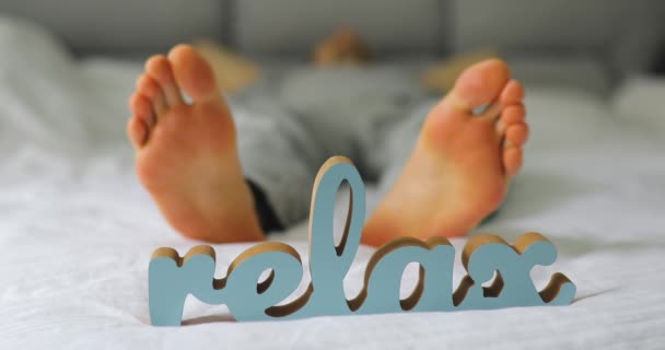 Concepto relajante. Piernas masculinas acostadas en una cama . — Vídeos de Stock