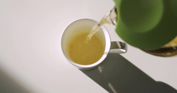 Verser le thé vert dans une tasse blanche, vue du dessus, audio original inclus 