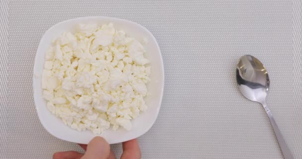 Put cottage cheese in bowl on a table and eating it, top view — Stock Video