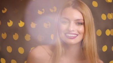 Sarı ışık bokeh, ağır çekim kamera bakarak gülümseyen bir modeldir