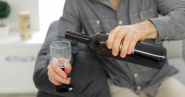 Anonieme man wijn binnenstromen wijnglas thuis — Stockvideo