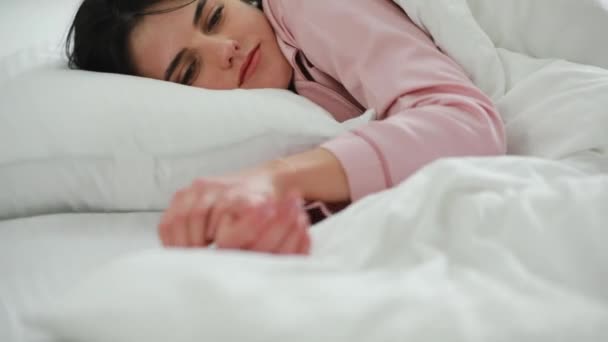 La mujer se despierta por la mañana en la cama — Vídeos de Stock