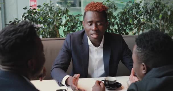 Africano prova algo para seus amigos em um café — Vídeo de Stock