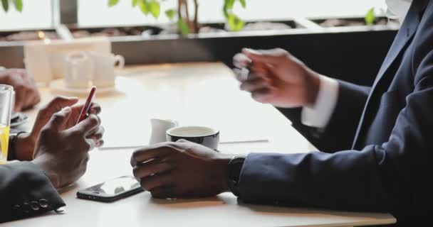 Mãos de empresários africanos falando em um café — Vídeo de Stock