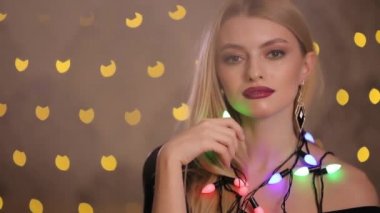 Güzel manken arka planda sarı ışık bokeh, yavaş hareket elektrik garland ile çalış