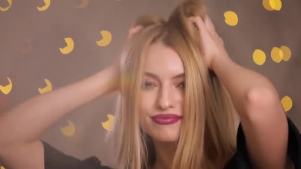 Женщина-кокетка флиртует, позирует на камеру, замедленная съемка, жёлтый фон боке — стоковое видео