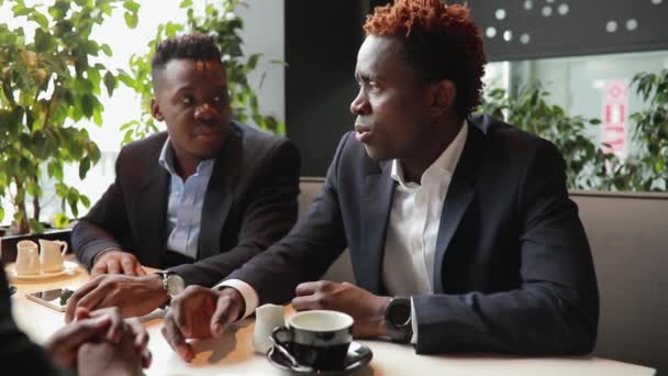 Друзья бизнесменов отдыхают в кафе — стоковое видео