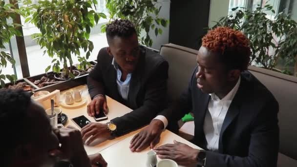 Друзья бизнесменов отдыхают в кафе — стоковое видео
