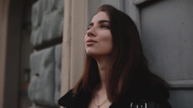 Kadın düşünme ve duvara yaslanmış temiz havanın tadını