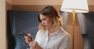 Mikrofiber kumaş kullanan kadın gözlük yüzey bez ile silerek