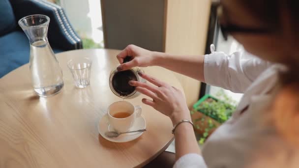 Mujer vierte el té en la taza en la cafetería — Vídeo de stock