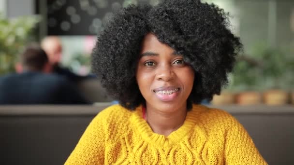 Mujer africana sonriendo en un café — Vídeos de Stock