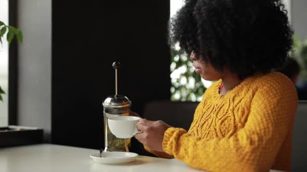 Vrouw giet de thee in beker in café — Stockvideo