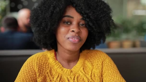 African kobieta uśmiechając się w kawiarni — Wideo stockowe