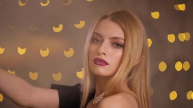 Güzel sarışın ve güzel yüzü poz sarı ışık bokeh, stüdyo vurdu, yavaş hareket ile oldukça çekici manken