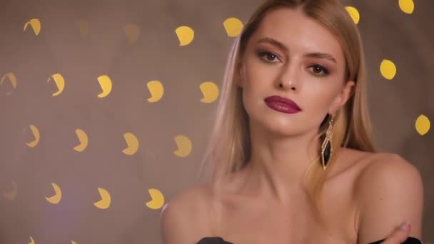 Preciosa modelo de moda con el pelo rubio posando, cámara lenta, fondo bokeh amarillo — Vídeo de stock