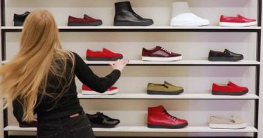 İnsanlar vitrin raflardan ayakkabı Dükkanı almak.