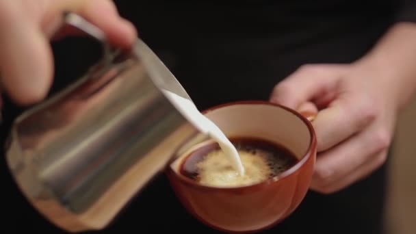 Barista vierte leche en un café para hacer café con leche o capuchino — Vídeo de stock