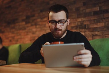 Tablet Pc içme kahve vasıl iş yemeği sırasında çalışan adam