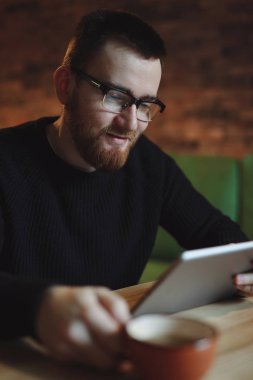 Tablet Pc içme kahve vasıl iş yemeği sırasında çalışan adam