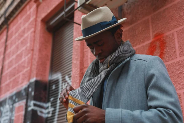 コートと赤い背景の建物で帽子でアフリカ系アメリカ人のストリートの肖像 — ストック写真