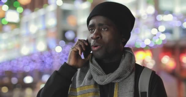African man talks by smartphone in city — Stock Video