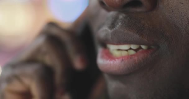 Afryki człowiek rozmowy przez smartfon w nocy miasto ustach zbliżenie — Wideo stockowe