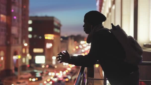 Silhouet van de mens op zoek naar stadsgezicht bij nacht denken en dromen over de toekomst — Stockvideo