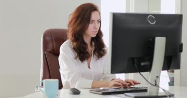 Güzel iş kadını ofiste bilgisayar monitörü seyir çalışma