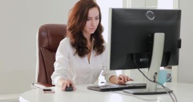 Güzel iş kadını ofiste bilgisayar monitörü seyir çalışma