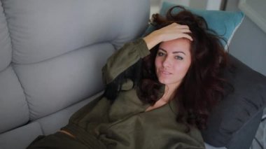 Güzel esmer kadın lay ve diğer dekoratif yastık üzerinde