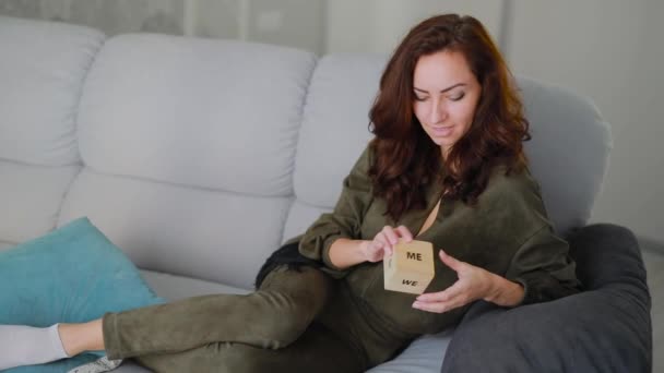 Hermosa mujer morena sosteniendo y mostrando un cubo con palabra disfrutar — Vídeos de Stock