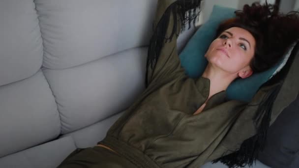 Красива брюнетка лежить і відпочиває на декоративній подушці — стокове відео