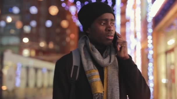 African man talks by smartphone in city — Stock Video