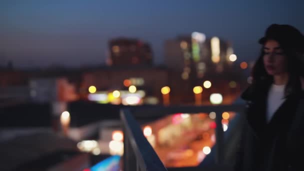 Femme sur terrasse attend avec impatience et profite du calme de la ville de nuit — Video