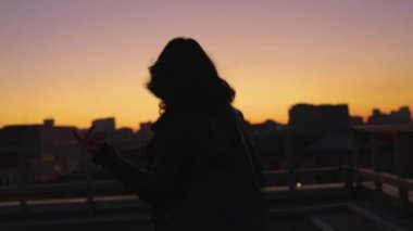 Yavaş çekimde kadının şehirde gün batımına doğru koşmak