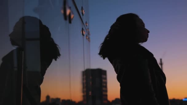 Странный силуэт женского портрета, движущегося на фоне заката неба — стоковое видео