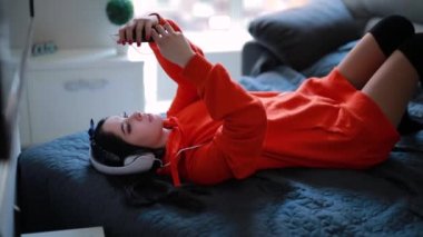 Sevimli kız kulaklık ev kanepe, müzik dinleme