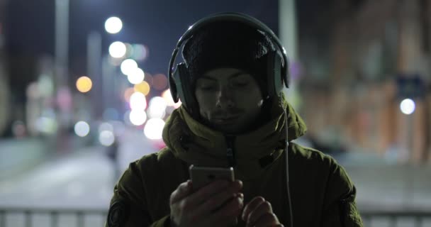 Homem mostrando uma tela verde vazia de smartphone na cidade noturna — Vídeo de Stock