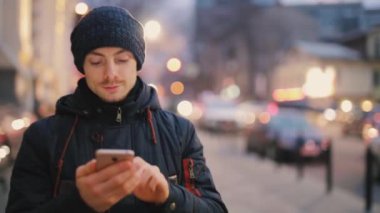 Adam bir gece şehir sokakta akıllı telefon yürüyüş kullanır