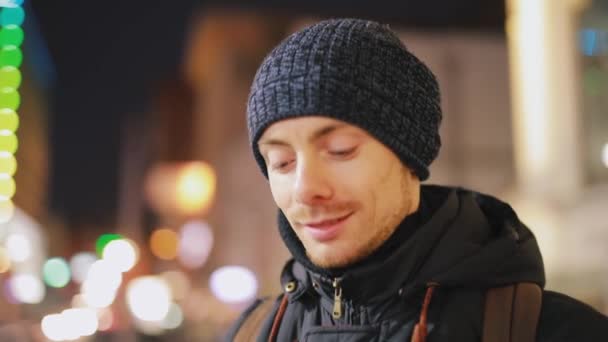 Человек отвечает на входящий звонок в ночном городе — стоковое видео