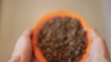 Kahve çekirdekleri ile turuncu plaka tutan adamın ilk kişi görünümü