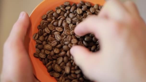 Вид от первого лица человека взять кофейные зёрна из оранжевой тарелки — стоковое видео