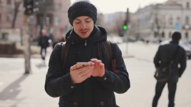 Adam bir şehirde sokak yürüyüş smartphone kullanır