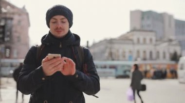 Adam bir şehirde sokak yürüyüş smartphone kullanır
